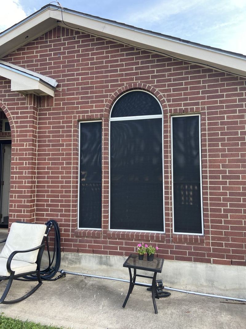 Arched top window solar screen on brick home