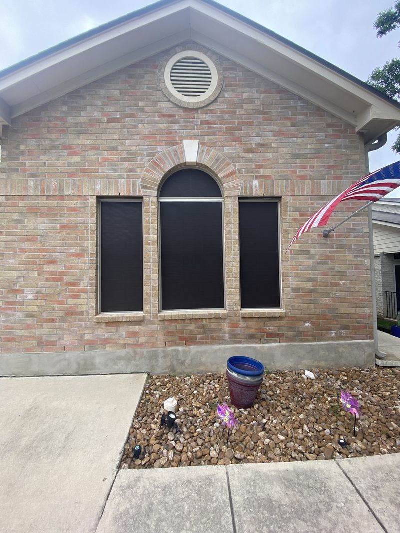 Arched window solar screen on brick home