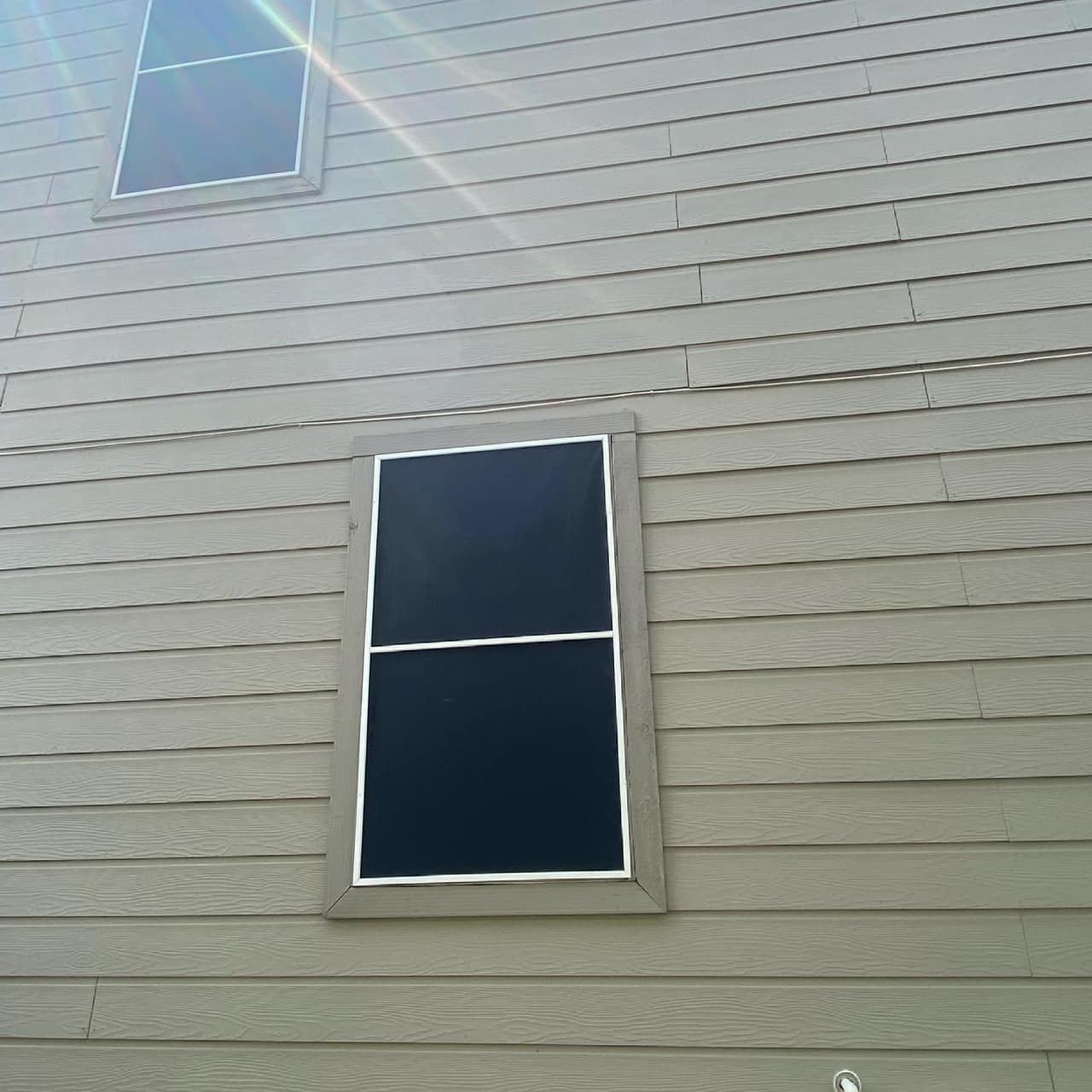 Close-up of a re-screened window, mesh fitted flush inside the frame